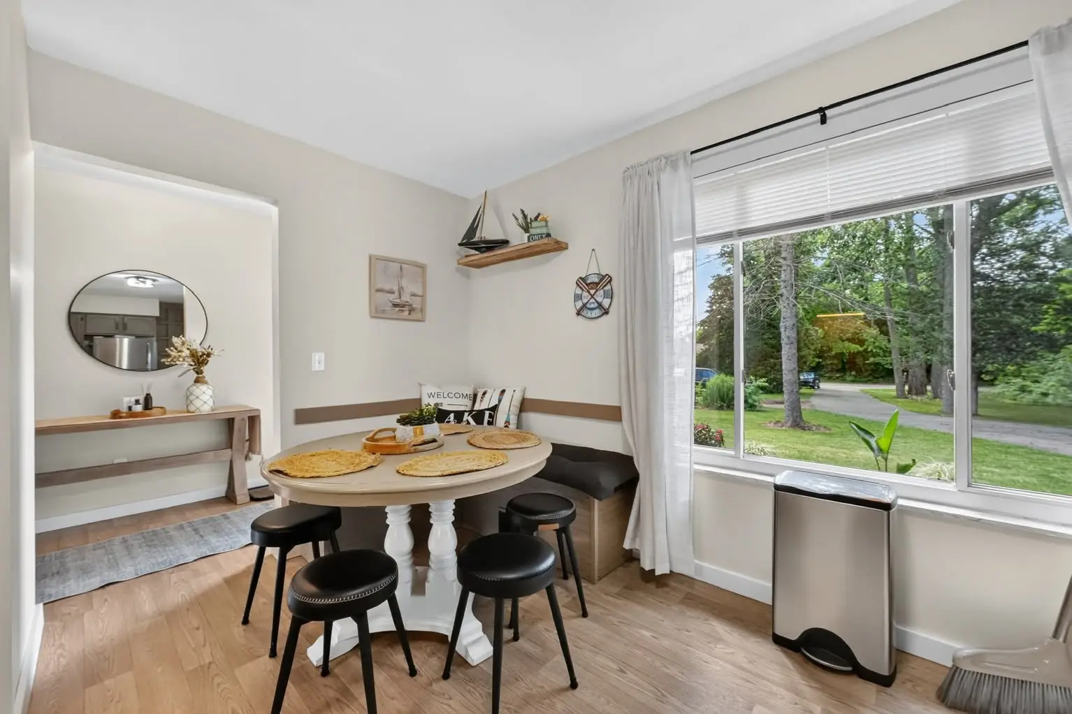 Bright dining nook with woven placemats and a view out to the yard
