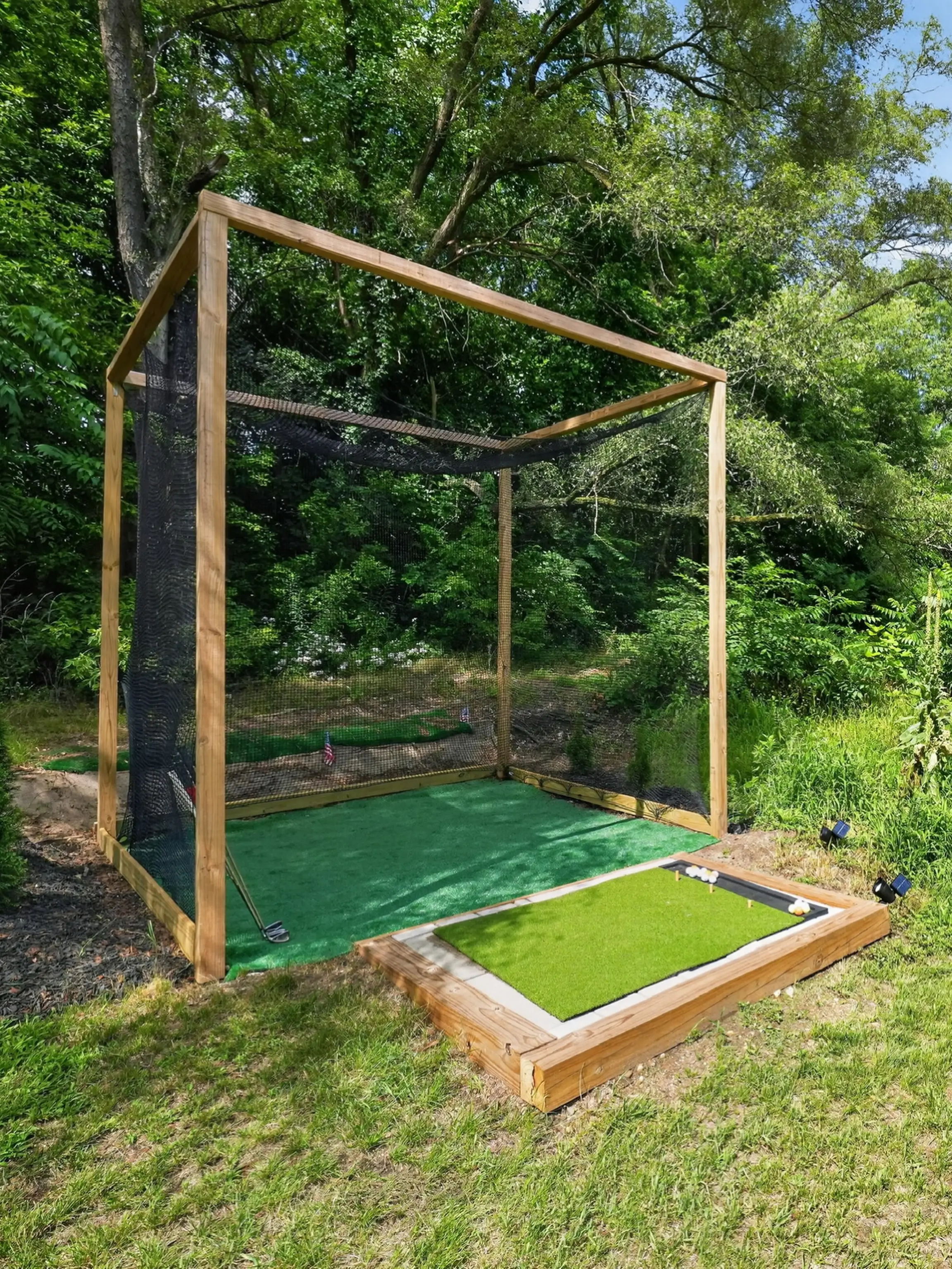 A golf driving net set up on the lawn beside the house